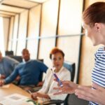 Kvinna som presnterar för arbetsgruppen