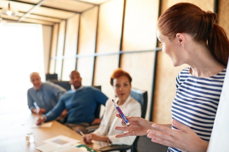 Kvinna som presnterar för arbetsgruppen