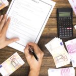 Man som skriver arbetskontrakt och pengar