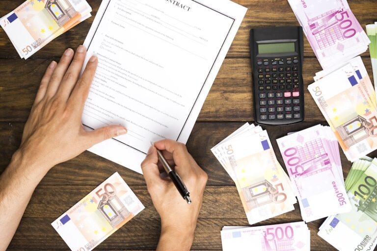 Man som skriver arbetskontrakt och pengar